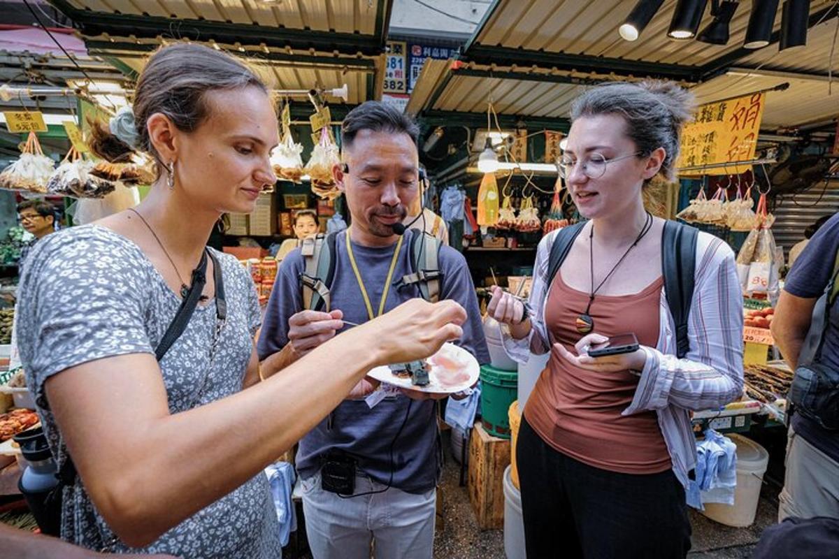 a group of people standing in a market eating food