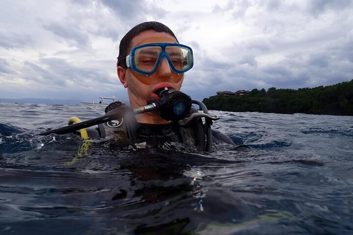 um homem na água com um snorkel e óculos de proteção