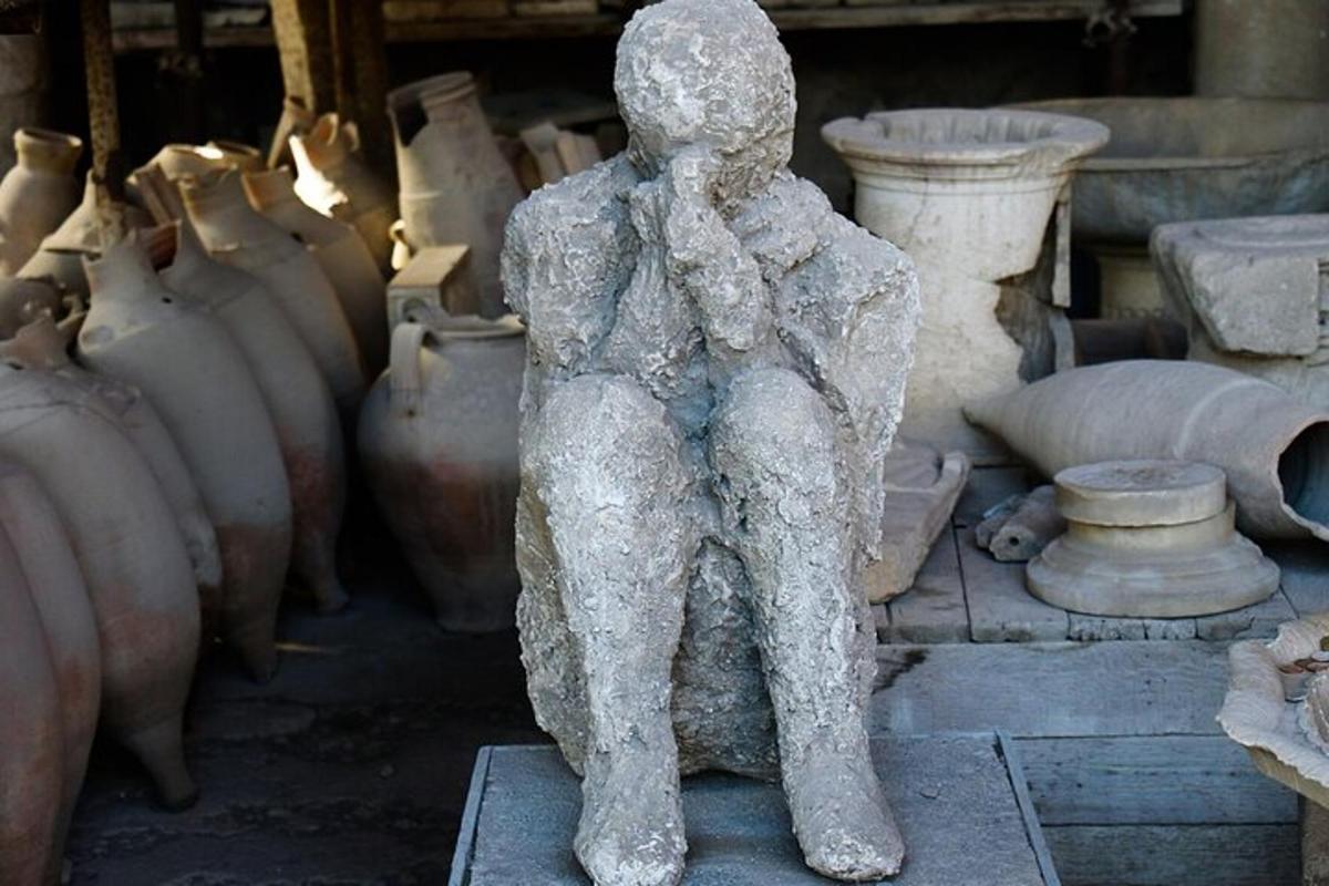 eine Statue einer Person, die vor Vasen steht