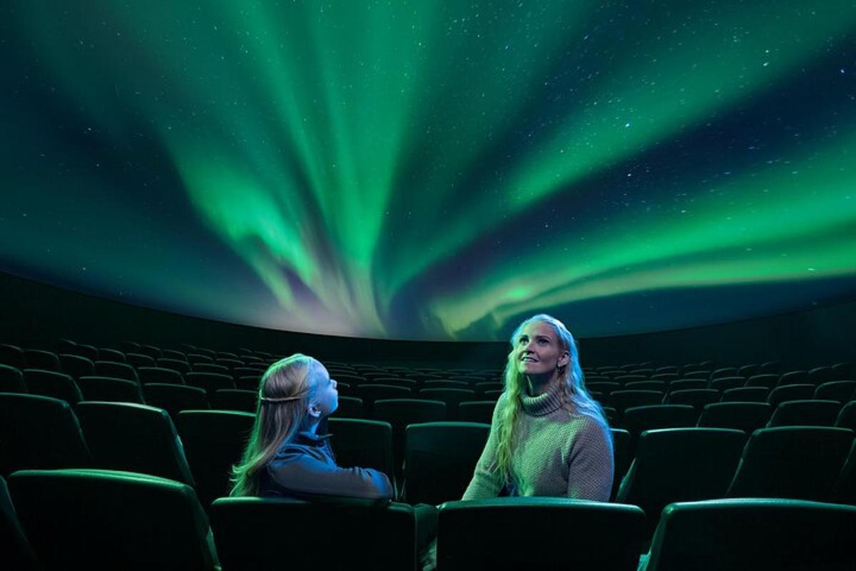 two women sitting in an auditorium watching the northern lights
