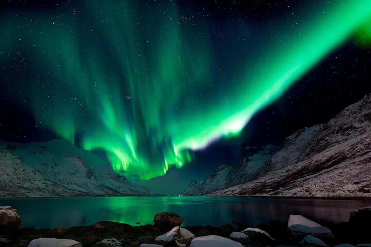 un'aurora sopra uno specchio d'acqua di notte