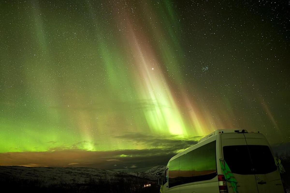 un camper parcheggiato sotto le stelle e l'aurora