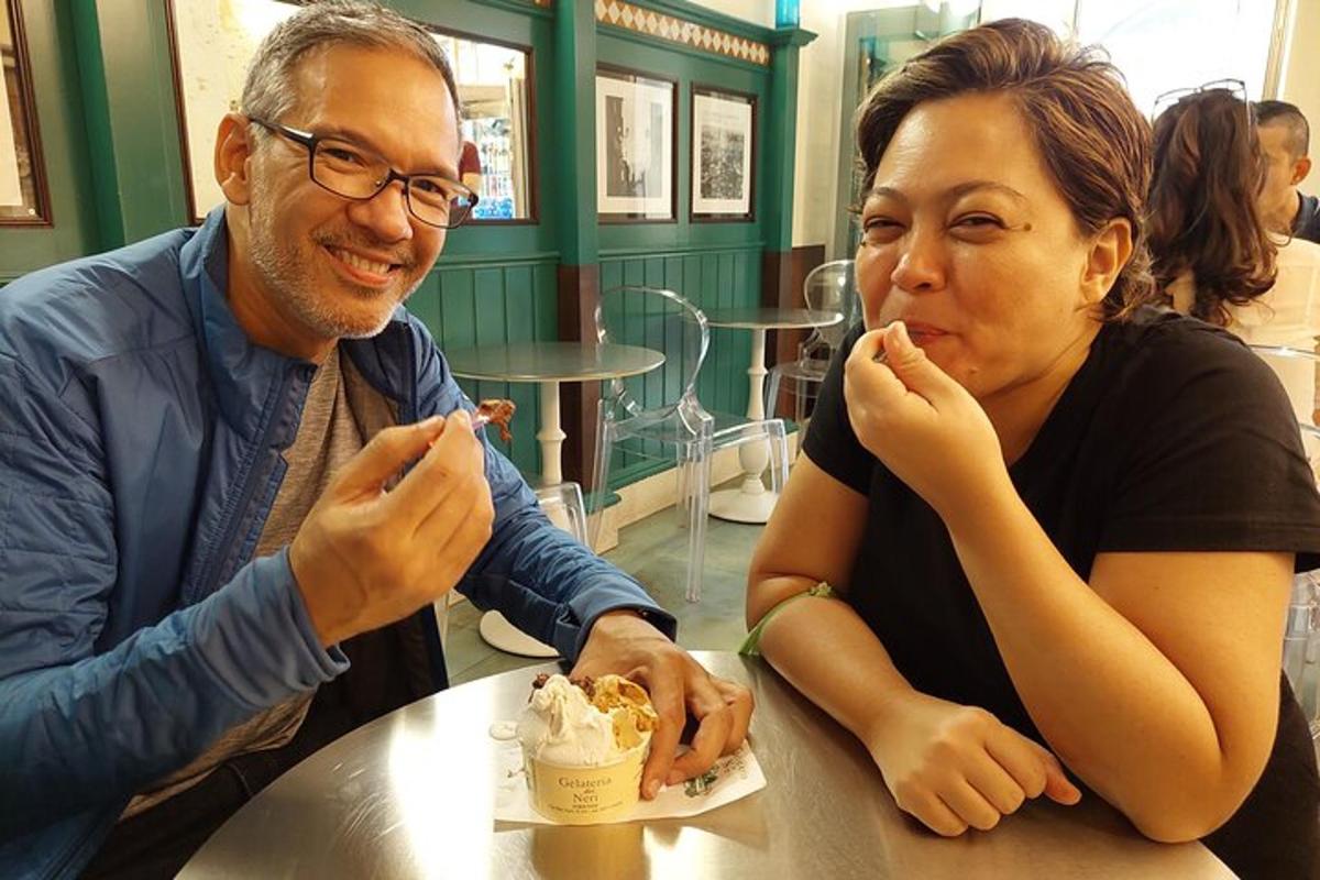 un uomo e una donna seduti a un tavolo che mangiano cibo