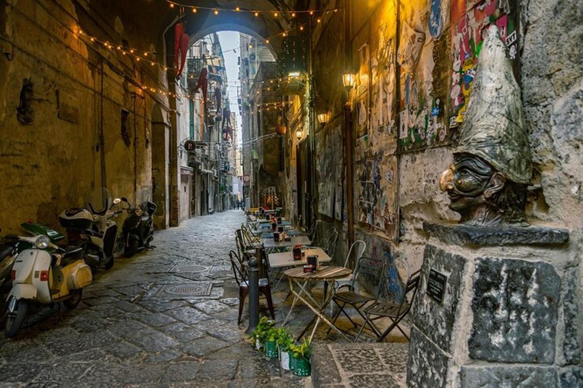Un callejón con mesas y sillas en un edificio con grafitis.