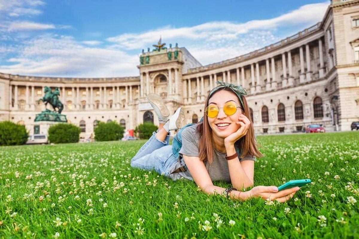 dívka ležící na trávě před budovou