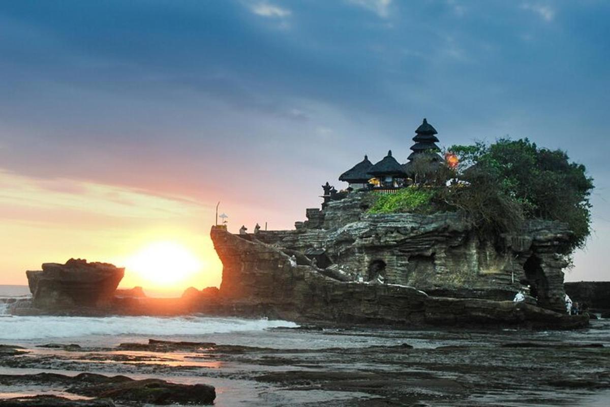 Un edificio en una isla en el océano al atardecer.
