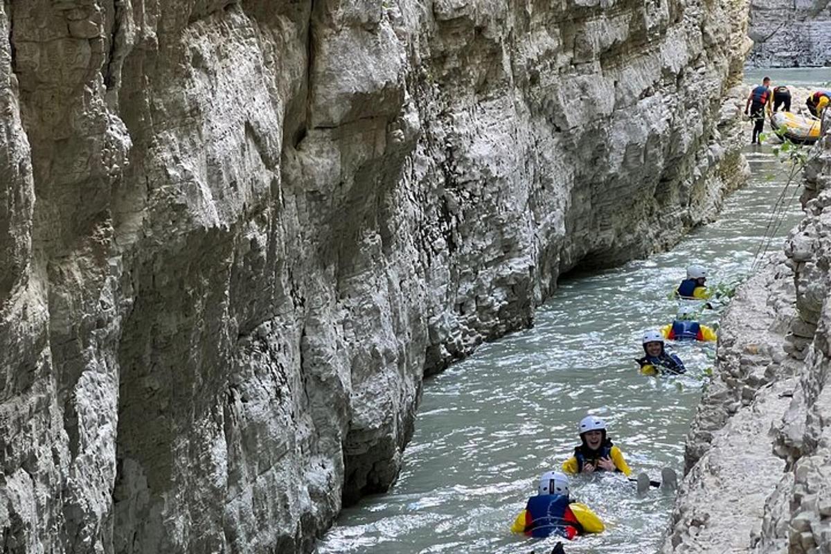 a group of people rafting down a river in a canyon