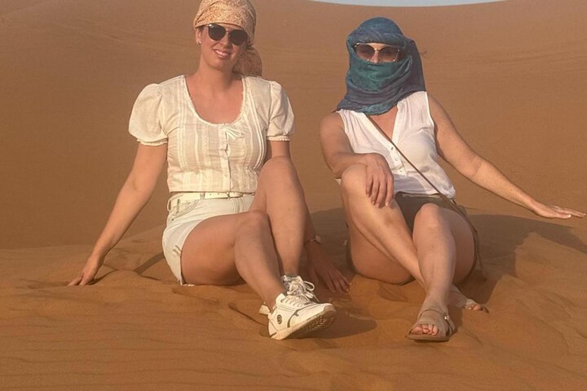 due donne sedute sulla sabbia nel deserto