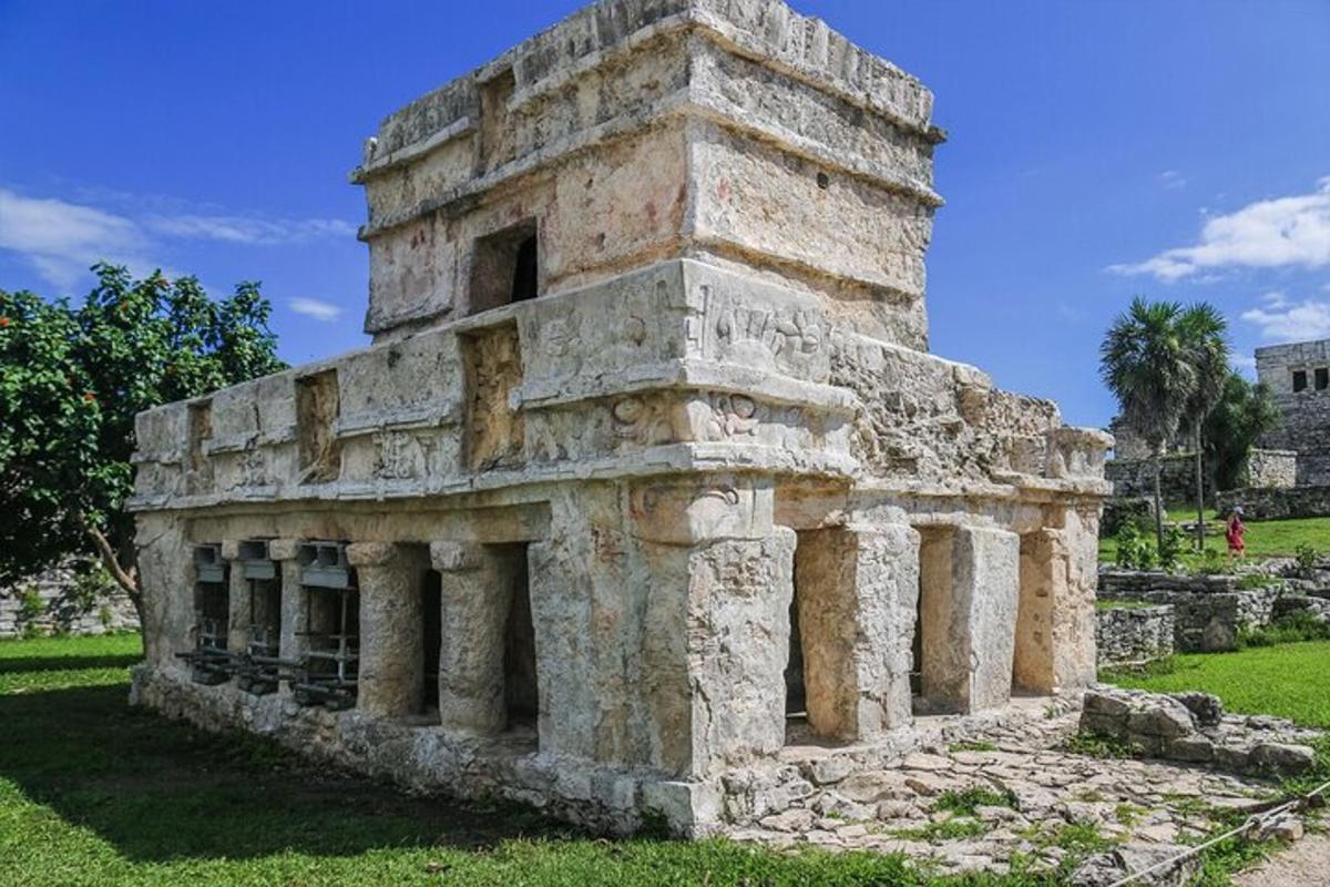 an ancient building with pillars in a field