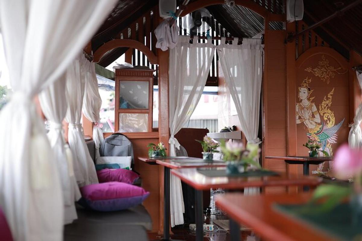 Una sala de tren con mesas y almohadas rosas.