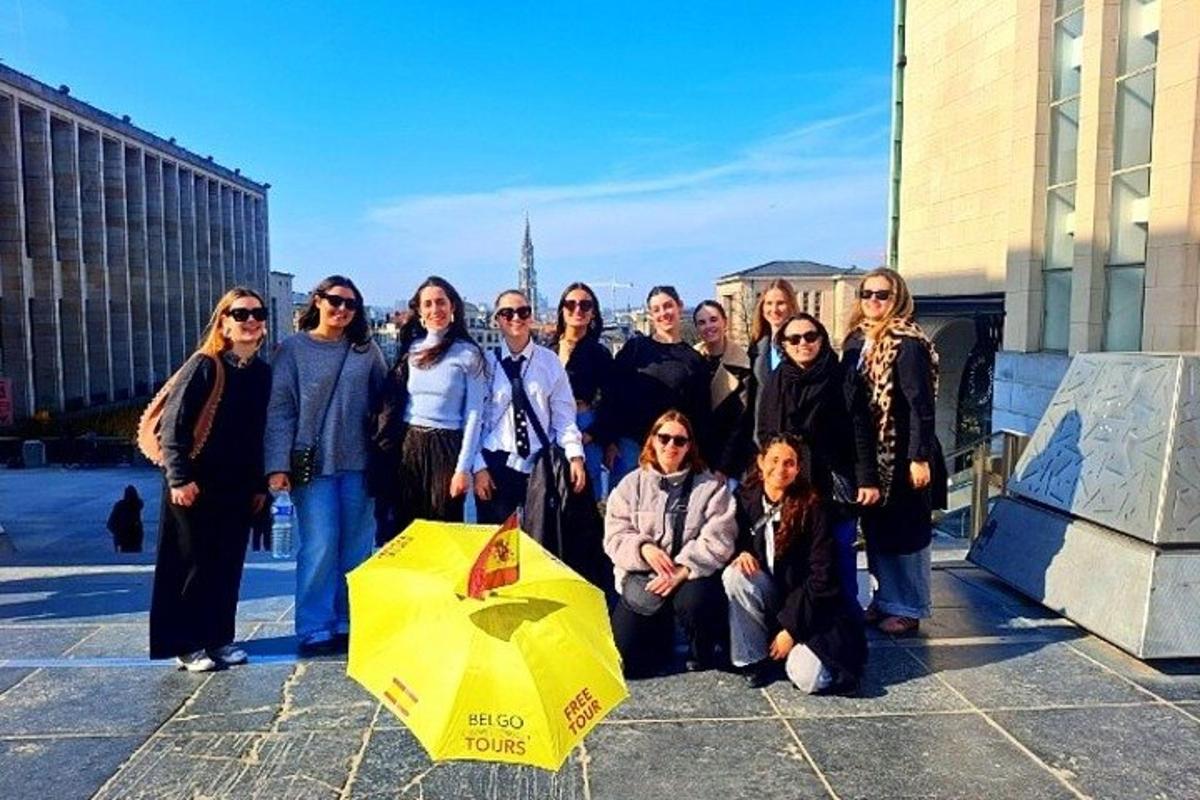 un gruppo di persone in posa per una foto con un ombrello giallo