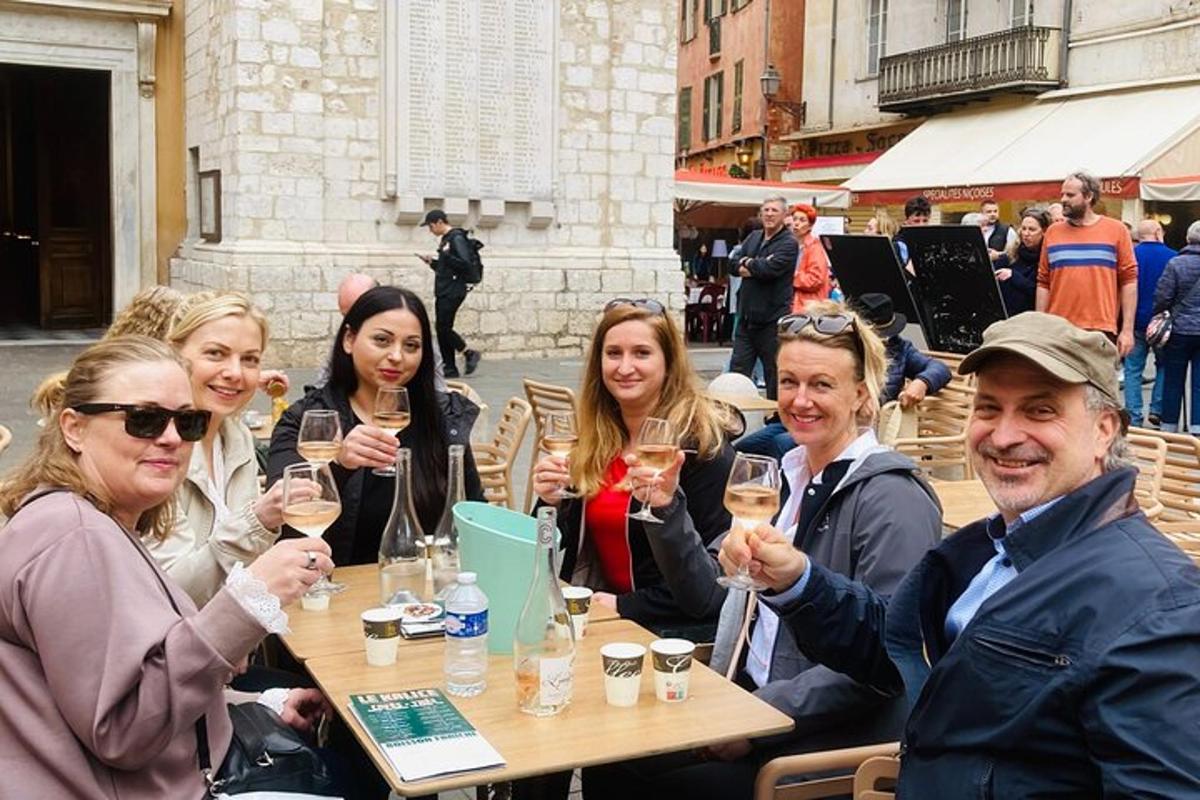 Un grupo de personas sentadas en una mesa sosteniendo copas de vino.