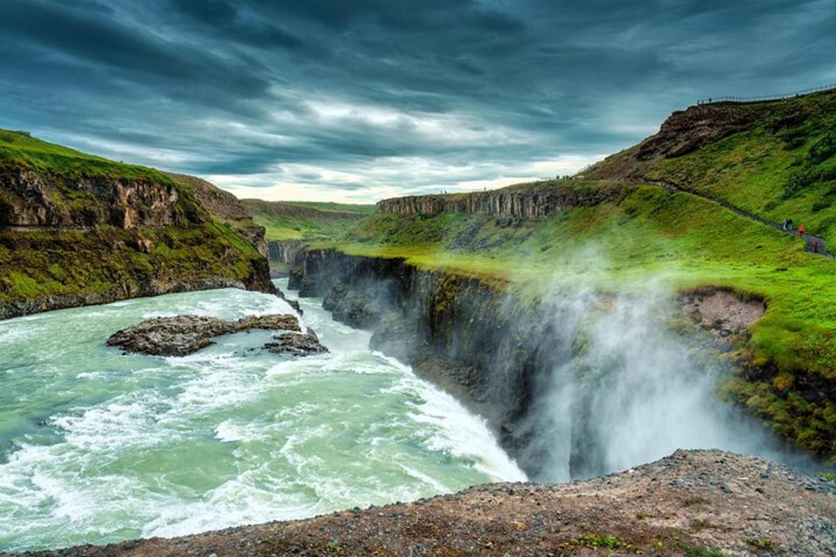 foss á klettahlíð við ána