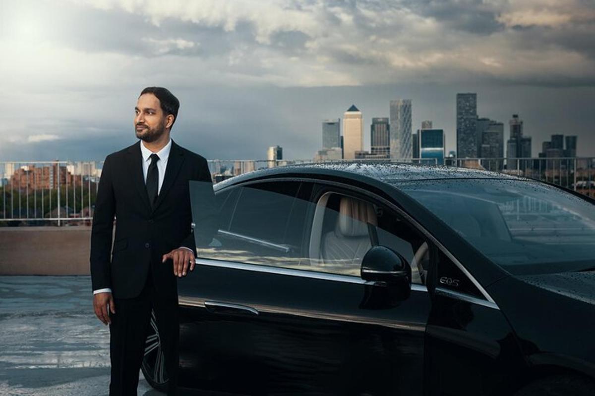 a man in a suit standing next to a car