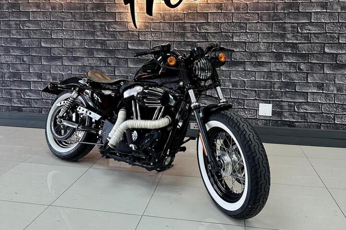 a black motorcycle parked in front of a brick wall
