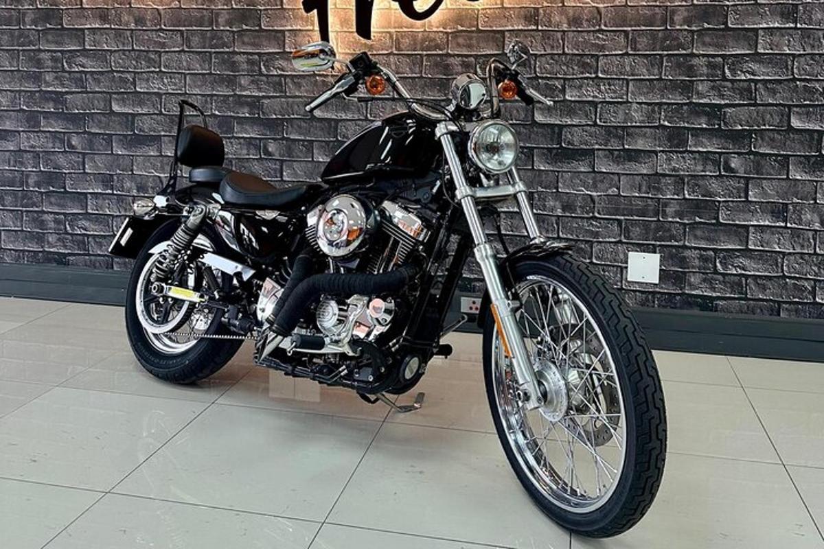 a black motorcycle parked in front of a brick wall