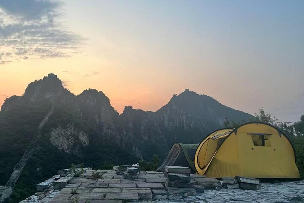 una tenda gialla in cima a una montagna