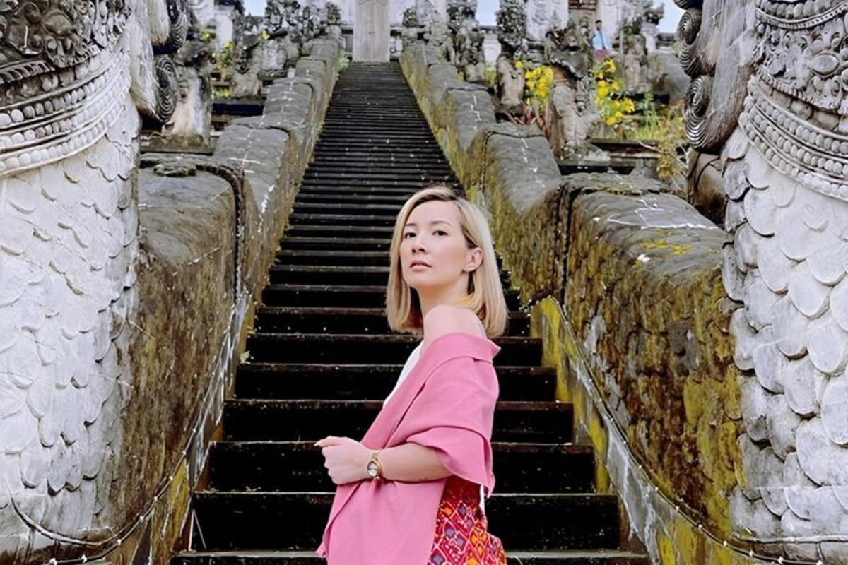 a woman standing on some stairs with her arms crossed