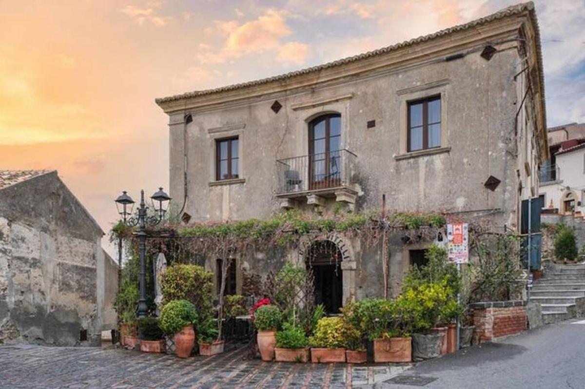 an old building with potted plants on a street