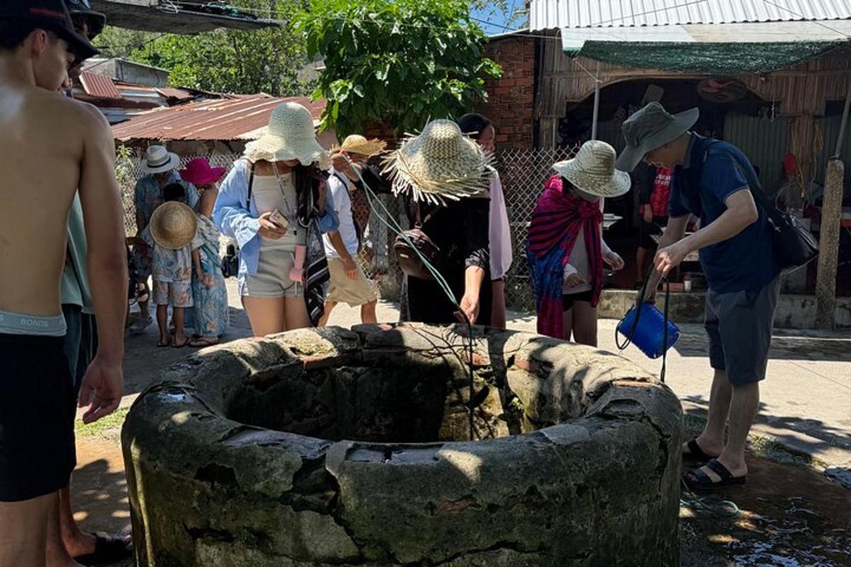 sekumpulan orang yang memakai topi jerami berdiri di sekeliling air pancut