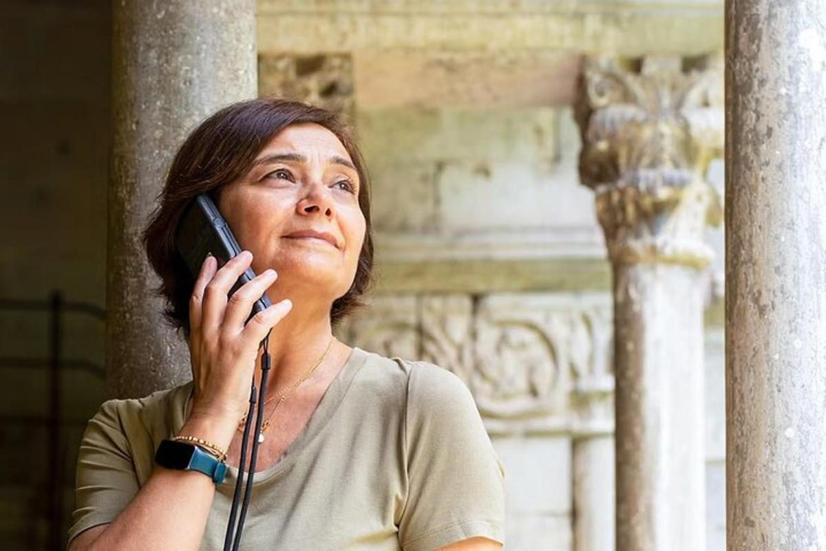 žena mluvící po mobilním telefonu před budovou