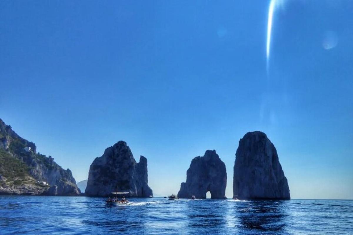 Un barco en el agua frente a unas grandes formaciones rocosas.