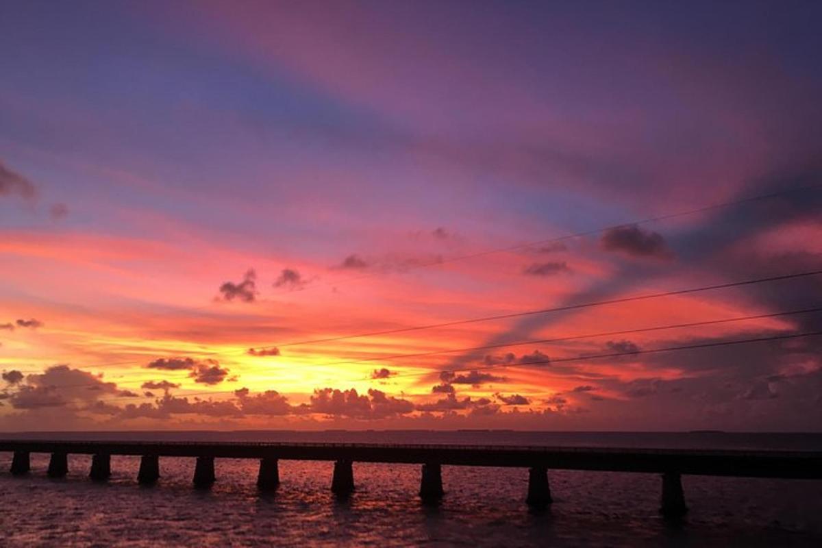 a sunset over a pier on the beach