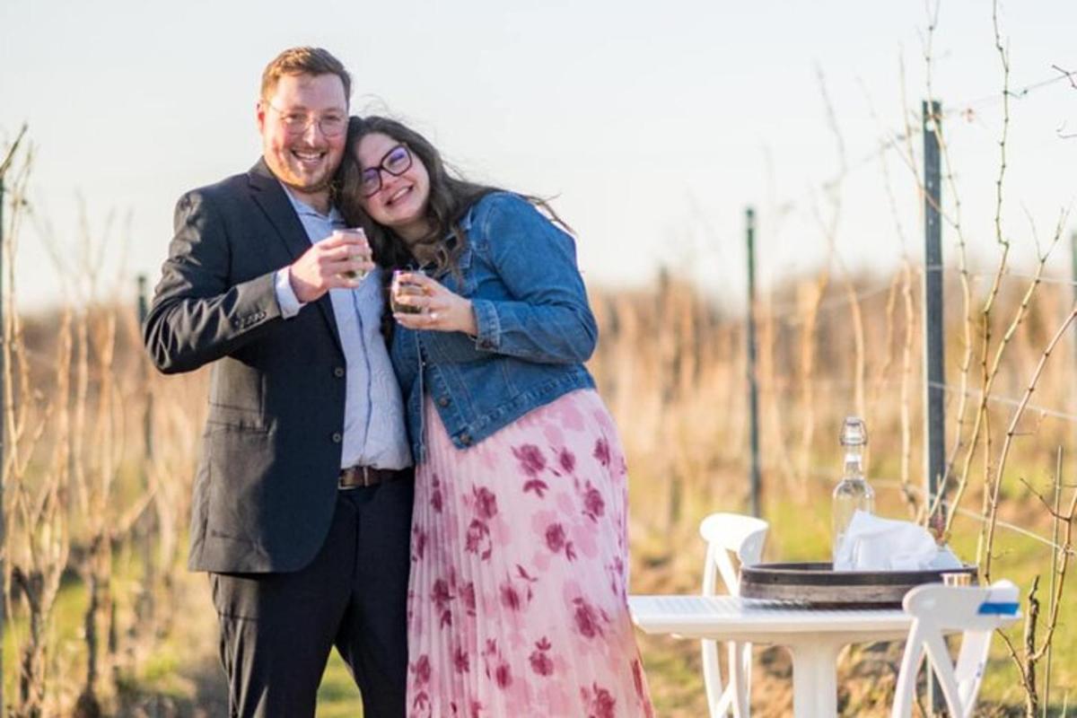 um homem e uma mulher bebendo vinho em frente a uma mesa