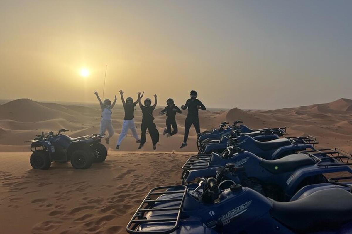 um grupo de pessoas pulando no deserto com suas motocicletas