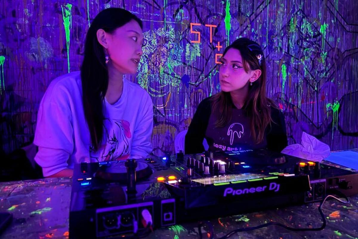 two women sitting in a room with purple lights