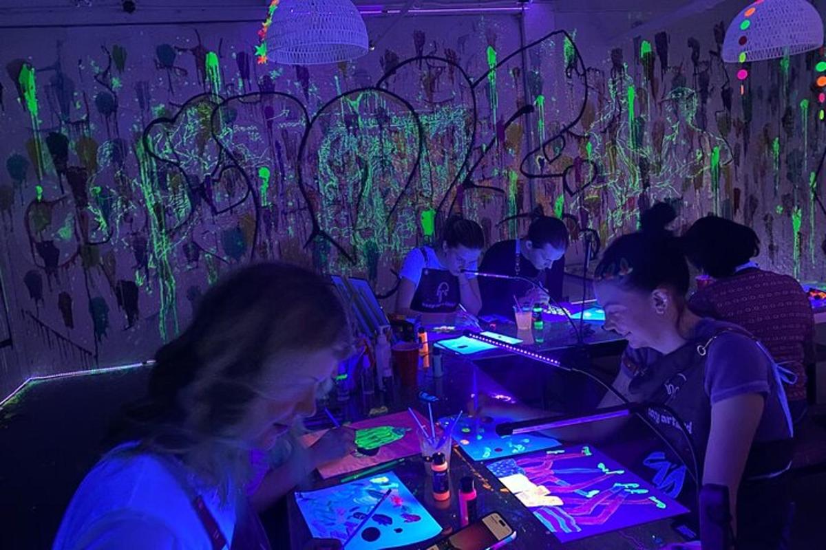 a group of people sitting at a bar with neon lights