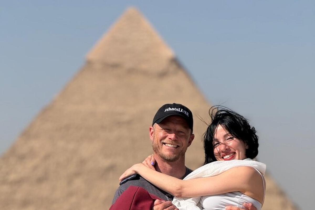 ein Mann und eine Frau umarmen sich vor den Pyramiden