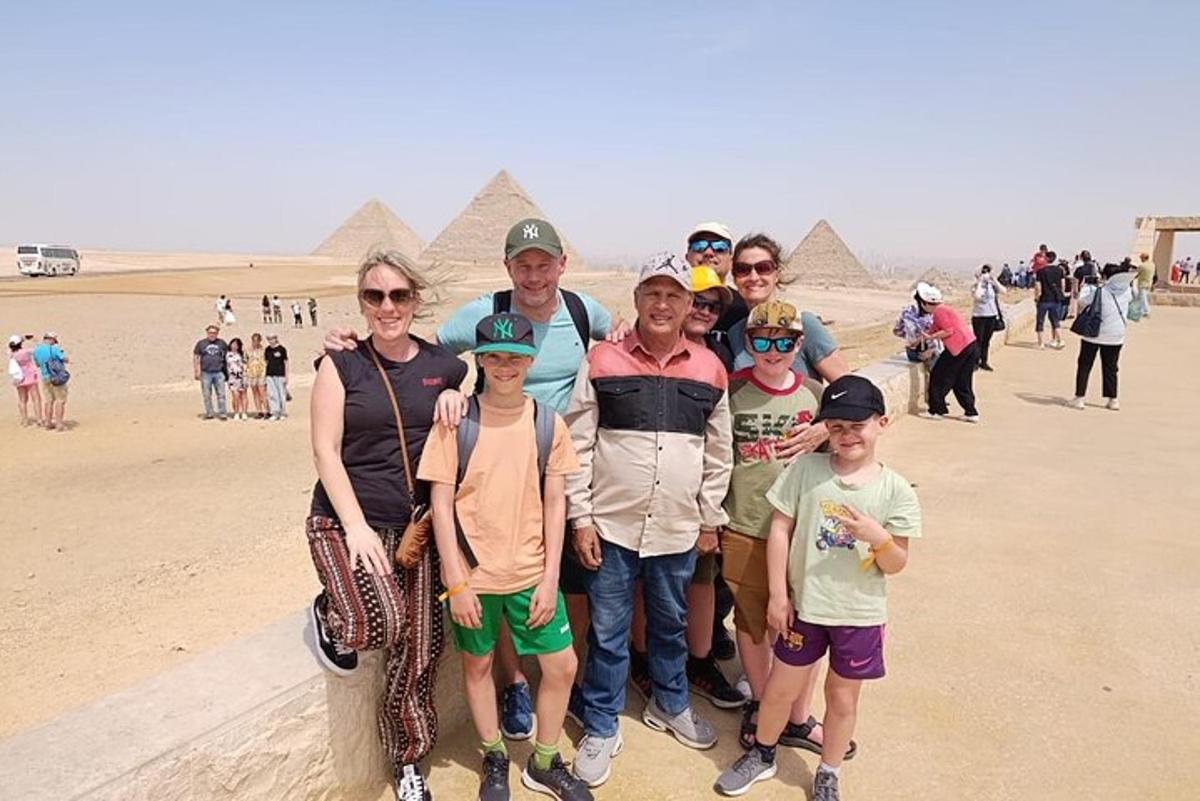 skupina lidí stojící před pyramidami