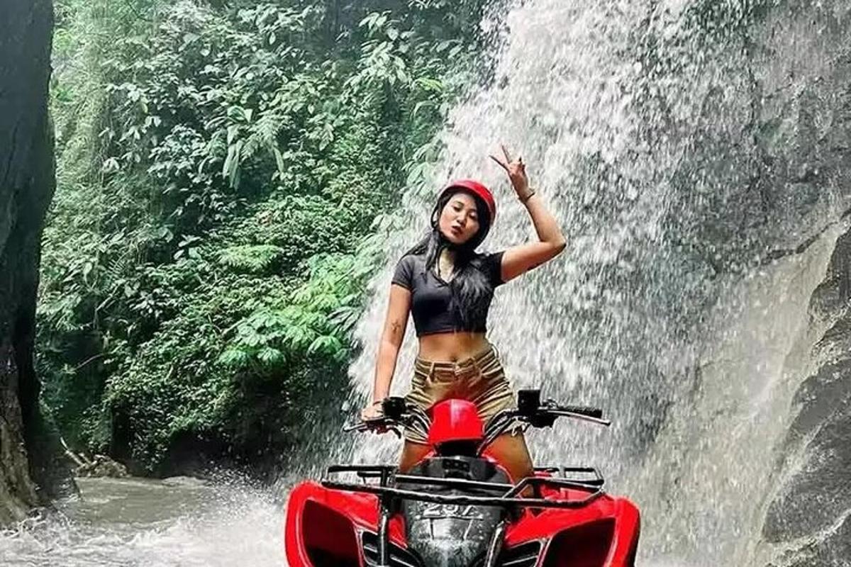egy nő motorozik egy vízesés előtt