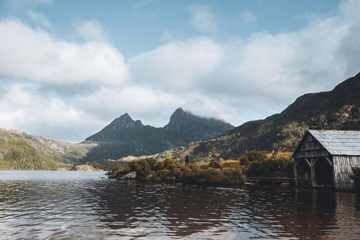 uma cabana no meio de um lago com montanhas