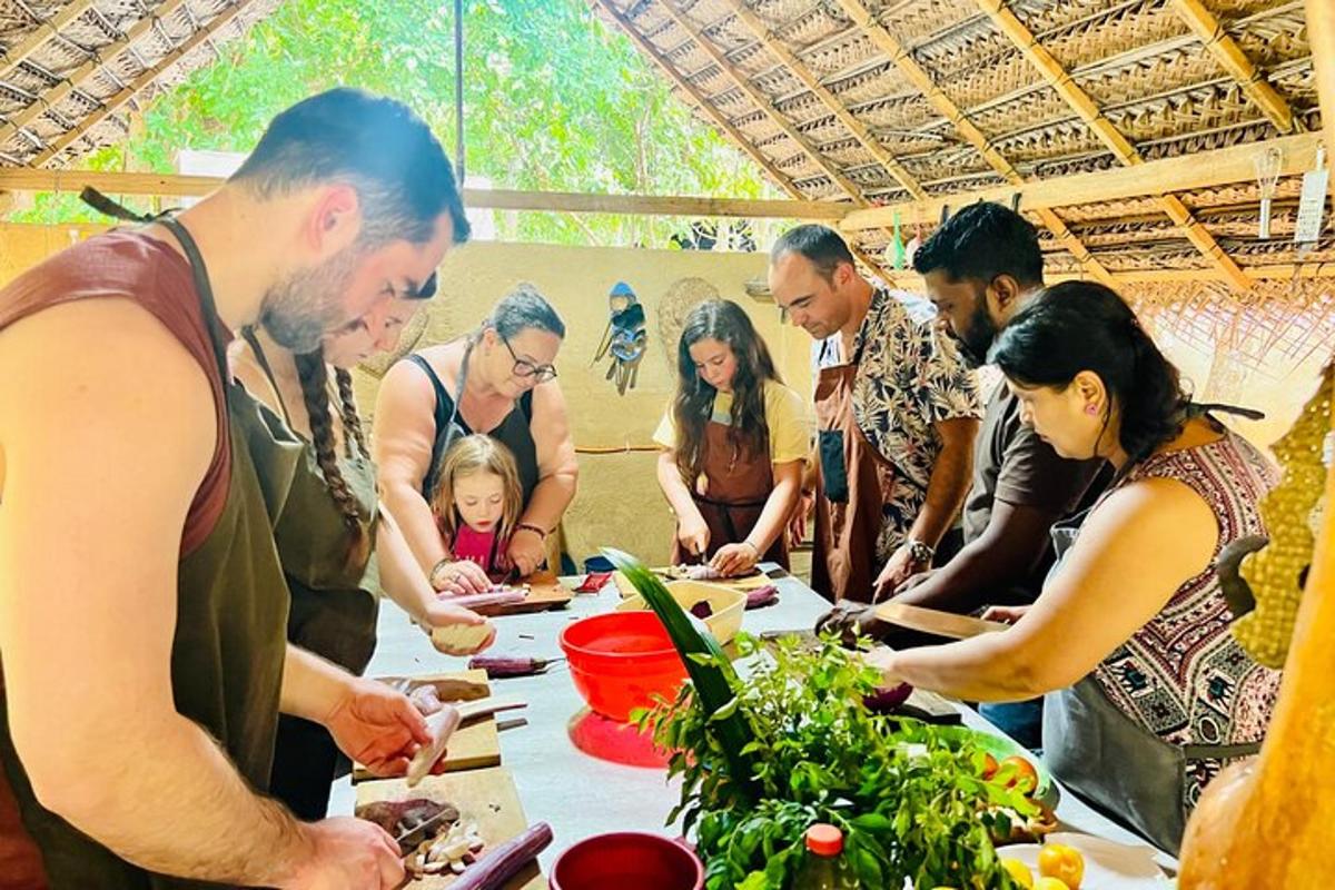 sekumpulan orang berdiri mengelilingi meja menyediakan makanan