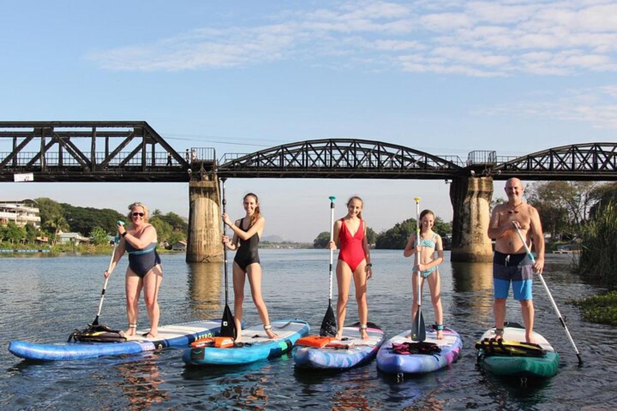 a group of people standing on paddle boards on the water