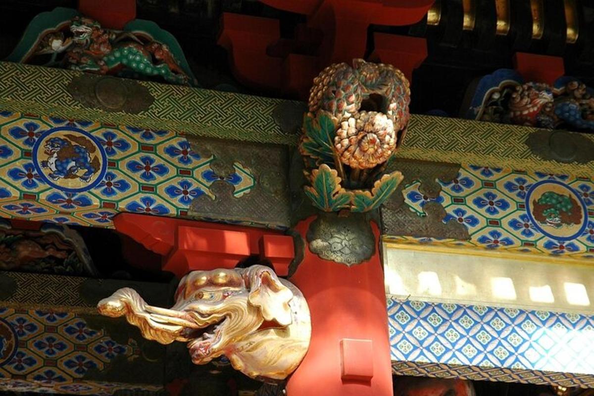 una estàtua d'un lleó i una màscara a la paret