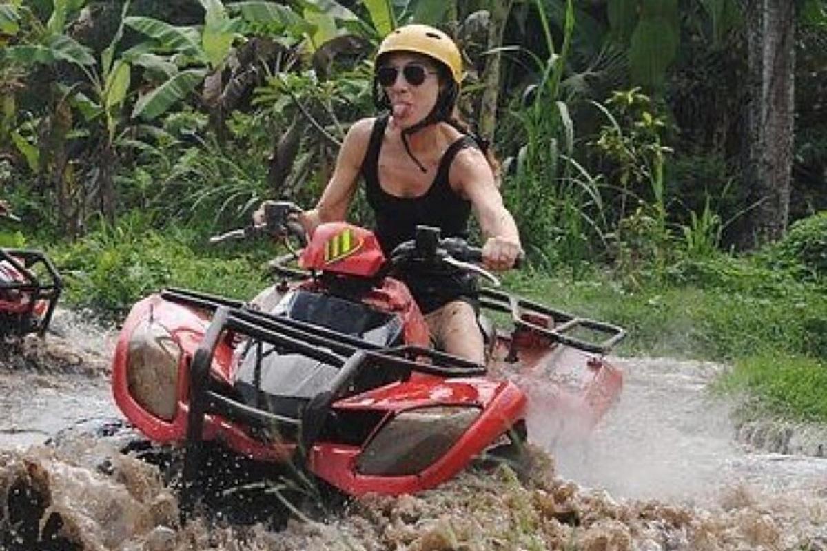 Una mujer conduciendo un vehículo todo terreno por el agua.