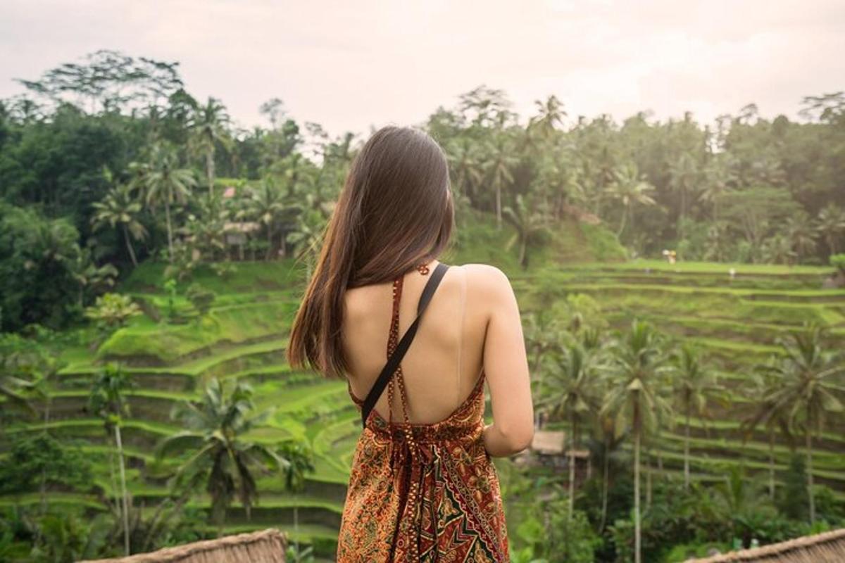 a woman standing on a bridge looking at a field