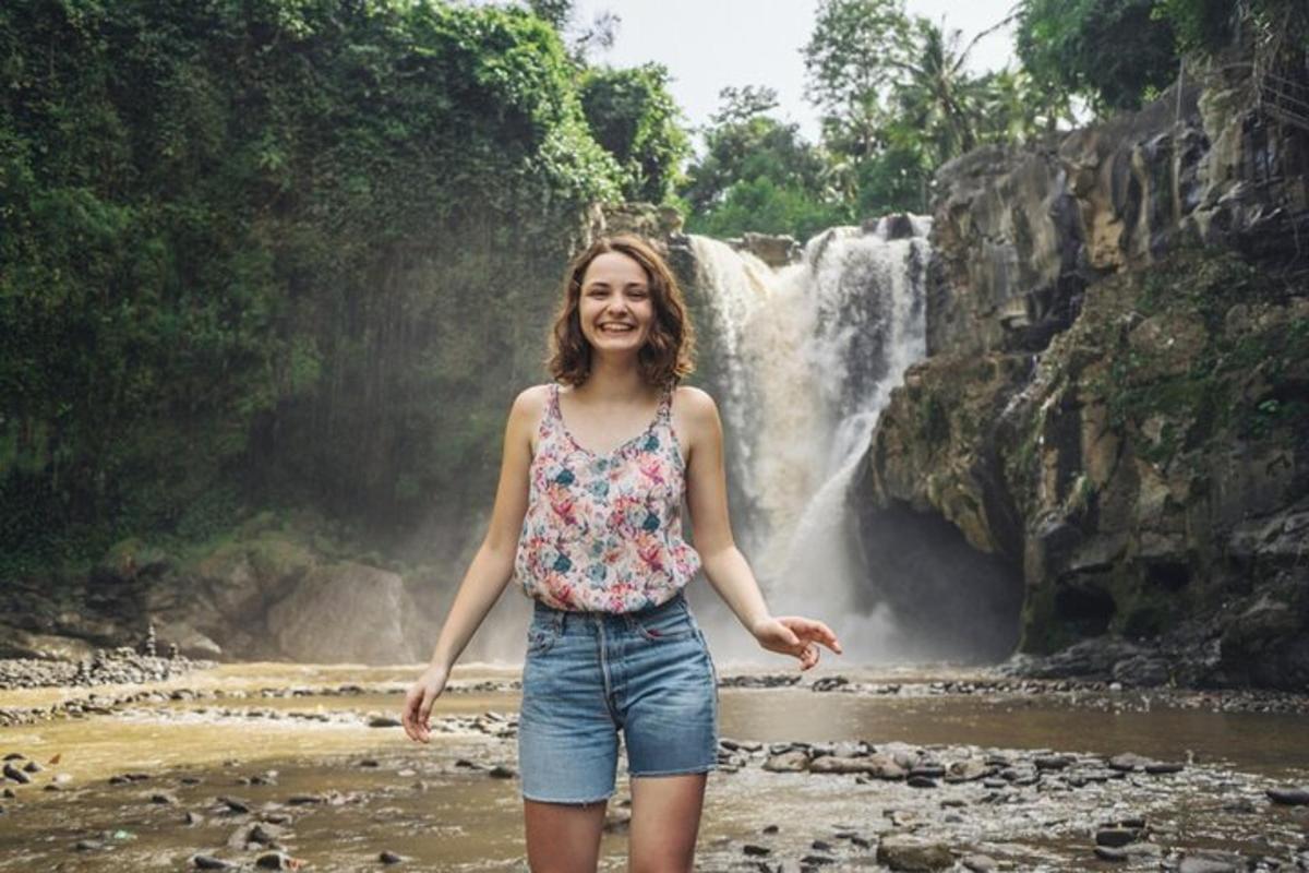 a woman standing in front of a waterfall