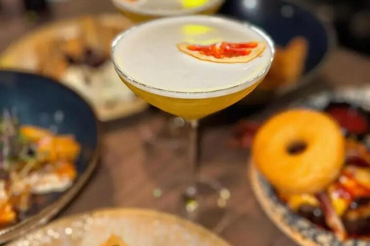 un bicchiere di vino appoggiato su un tavolo con piatti di cibo