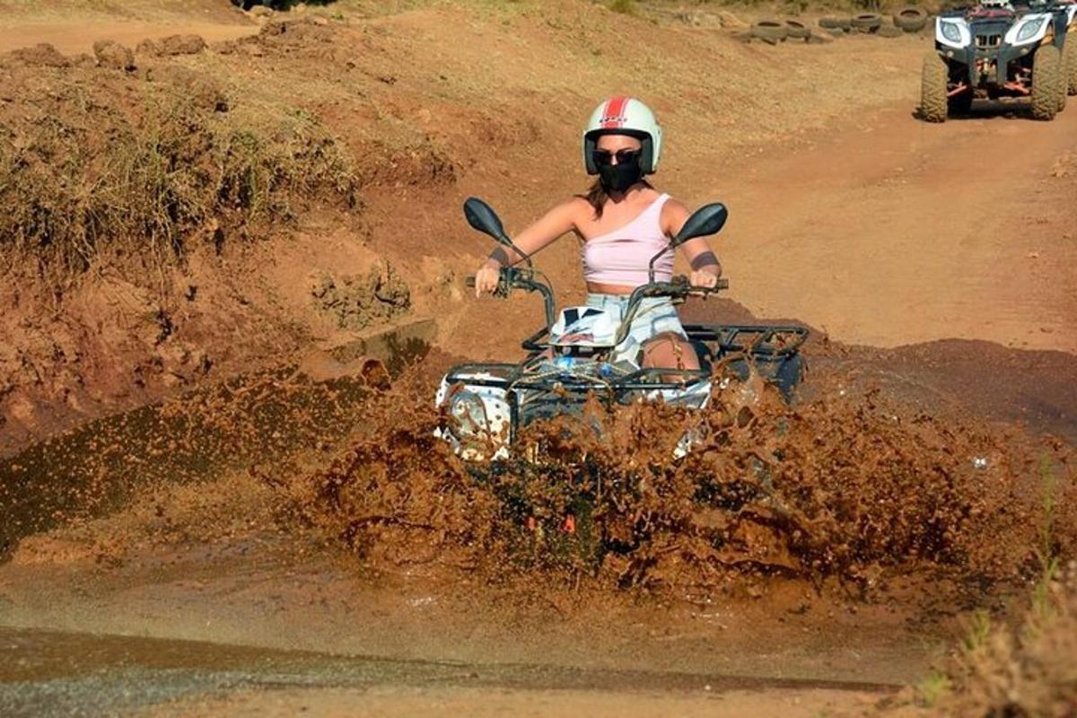 žena jedoucí na čtyřkolce přes prašné pole