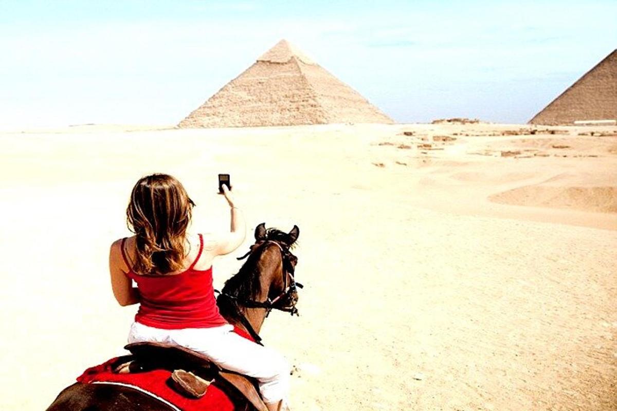 una donna a cavallo davanti alle piramidi