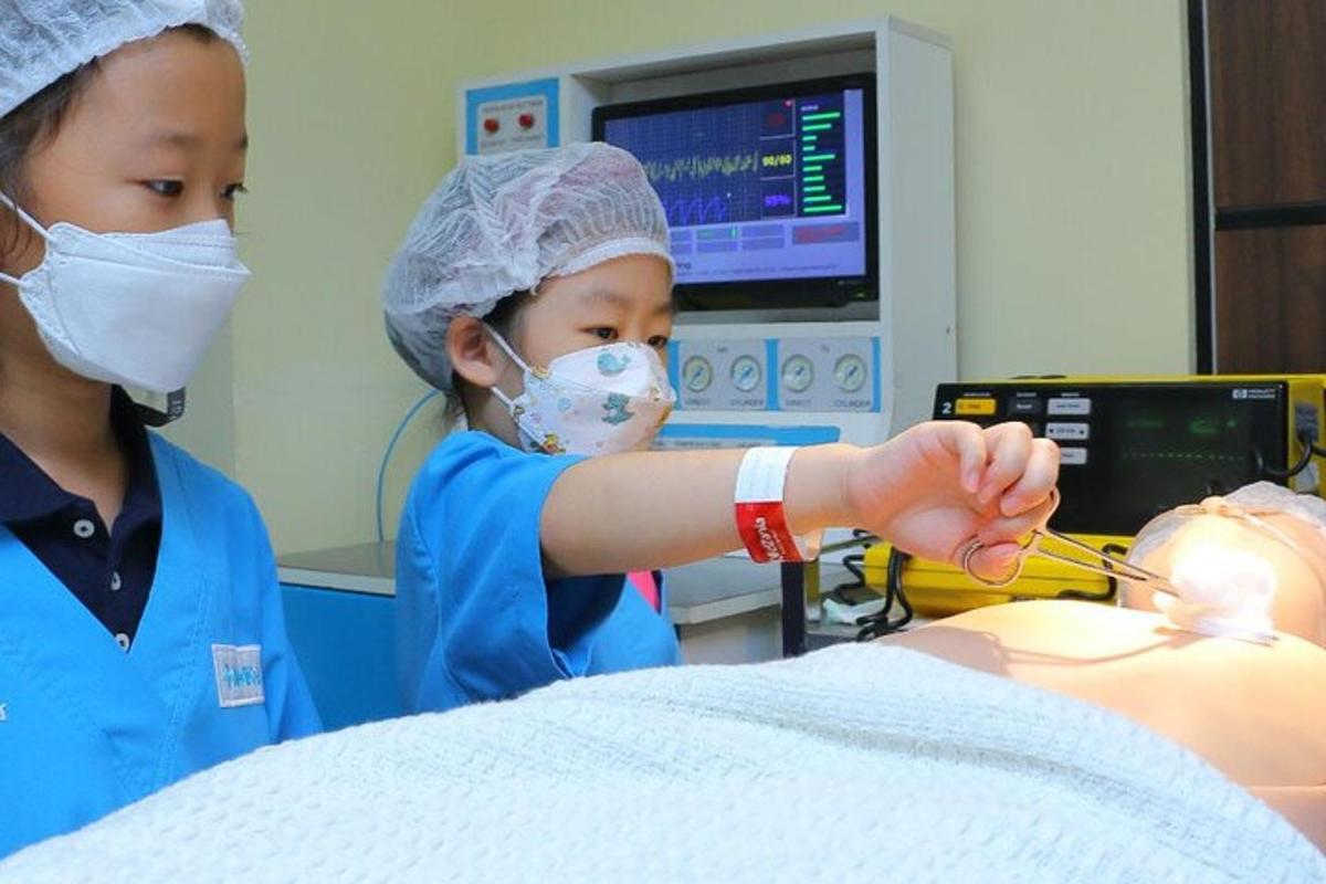 two girls in a dental clinic with a dummy