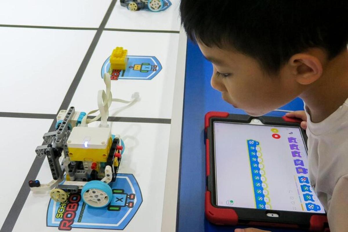 a young boy looking at a toy train on a tablet