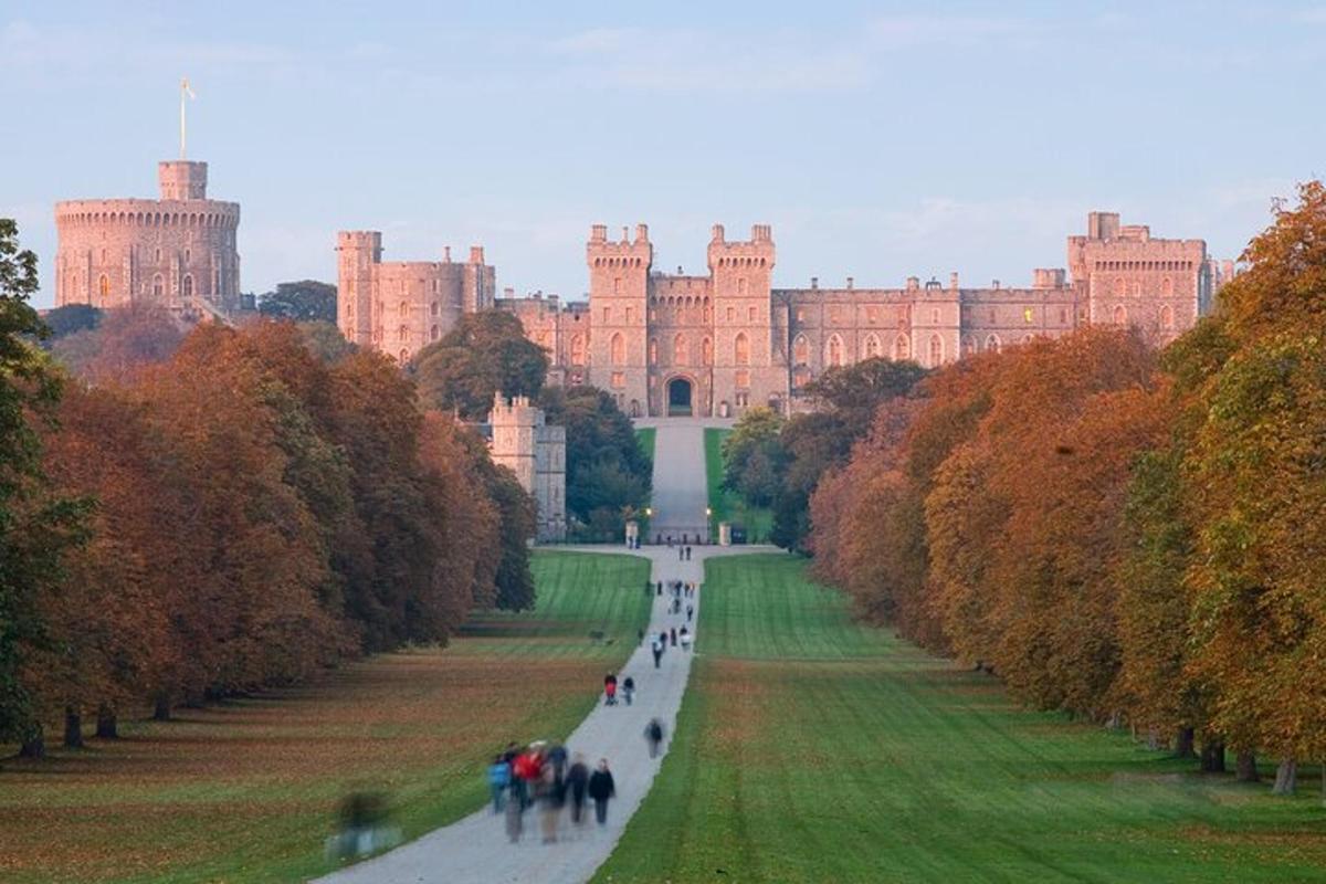 un grande castello in lontananza con persone che camminano lungo una strada
