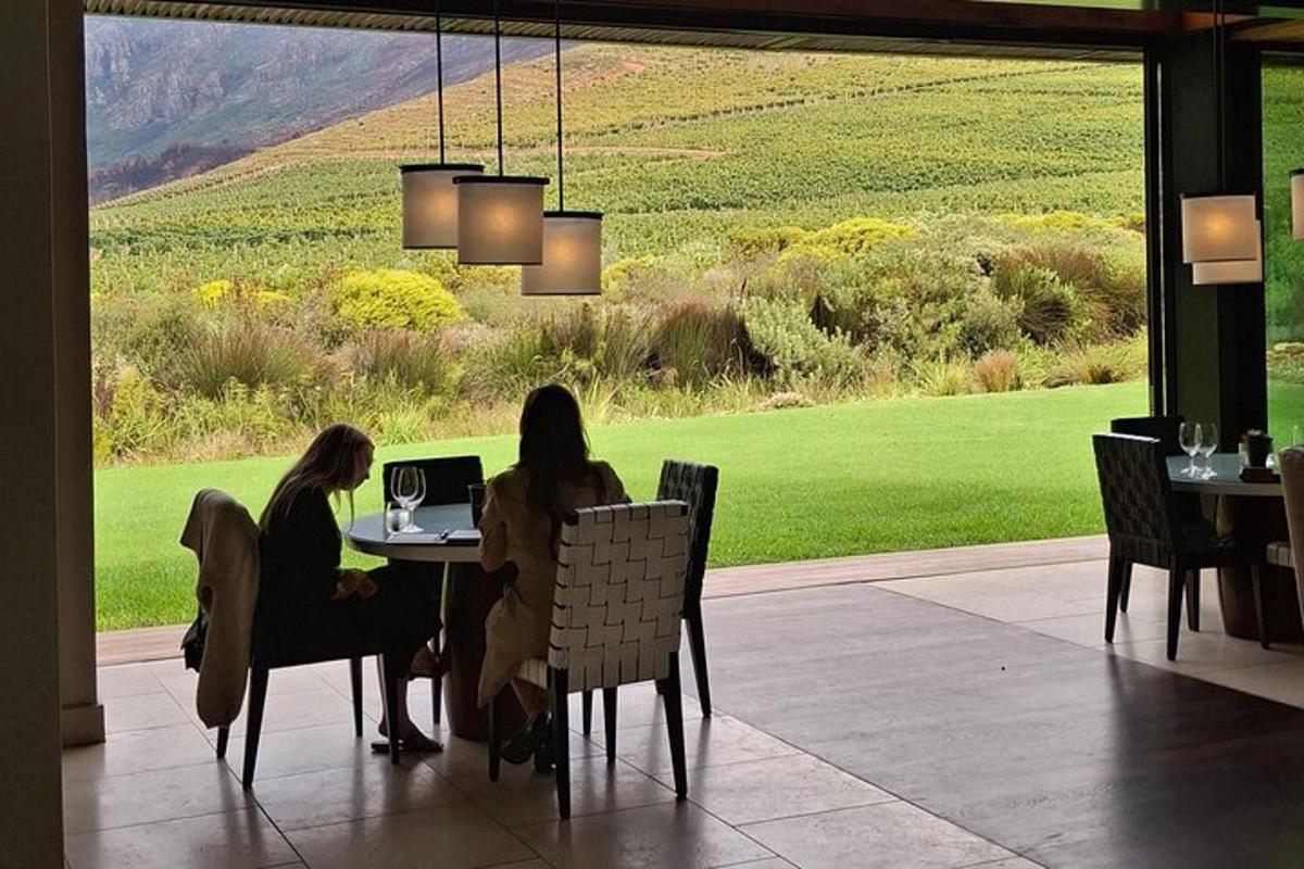 two women sitting at a table with a laptop