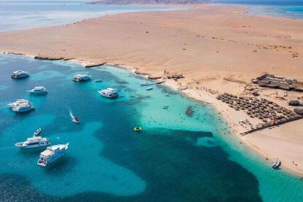 a group of boats in the water next to a beach