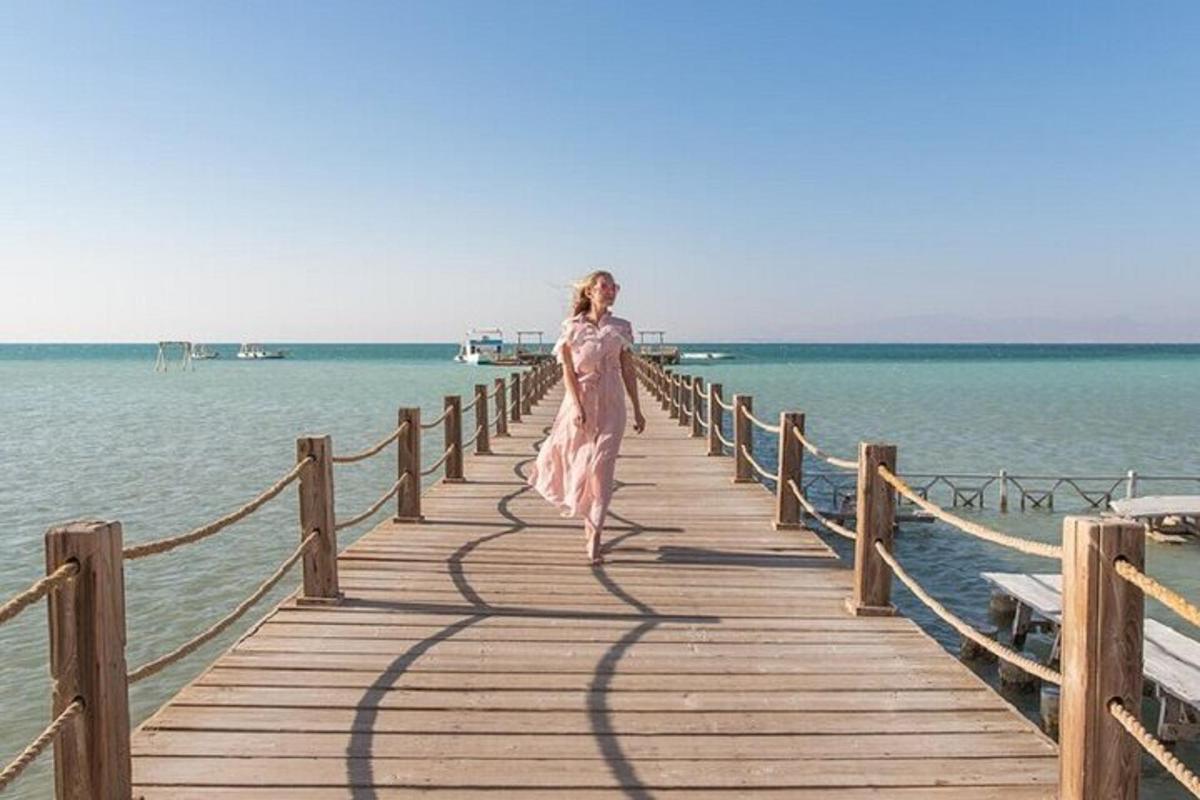 a woman in a dress walking on a wooden pier